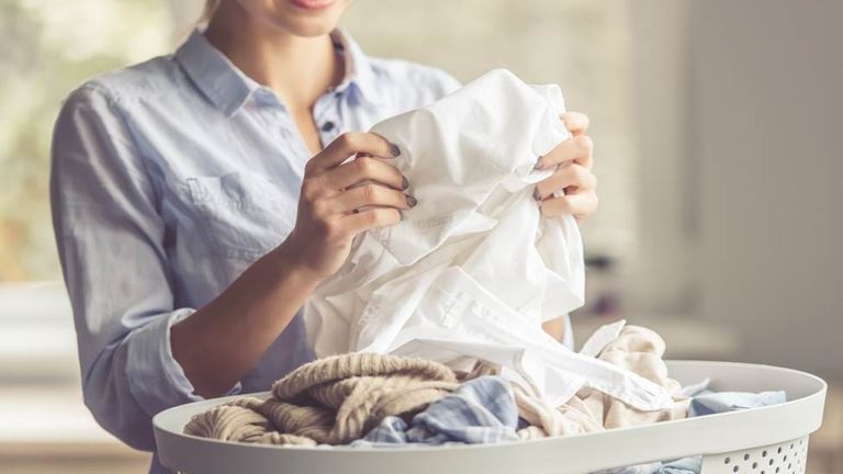 Woman folding clean clothes thanks to Soda Solvay